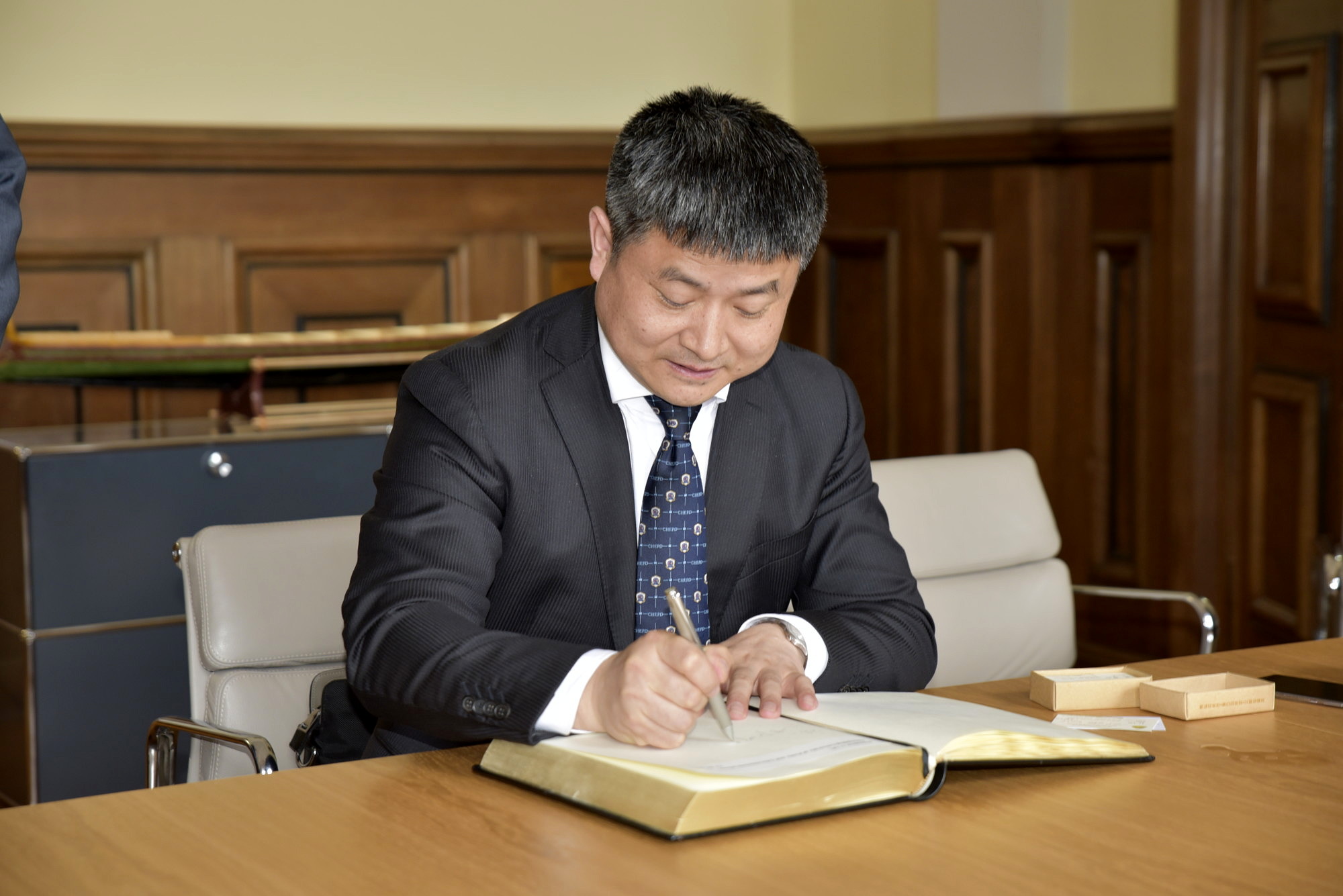 Der Präsident der Chonquing University of Posts and Telecommunications (CQUPT) trägt sich in das Gästebuch der FAU ein. (Bild: FAU/Rebecca Kleine Möllhoff)