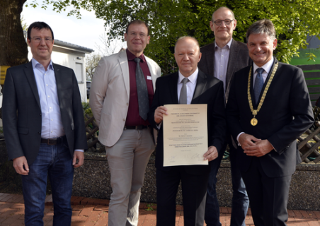 Dr. Comaniciu shows his certificate, other people are standing next to him