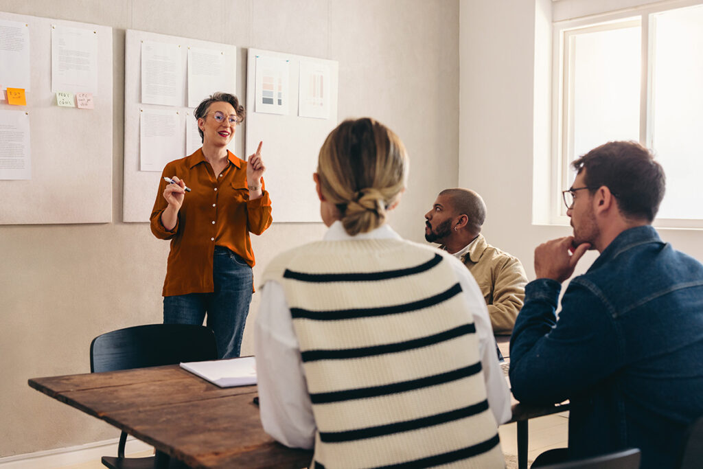 Mature designer pitching her idea to her team in a creative office